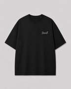 Voorkant van het zwarte NOTHING IS REAL T-shirt, met klein fakesniff-logo op de borst