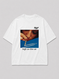 Wit oversized HIGH ON THIN AIR T-shirt van FAKESNIFF, print 'high on thin air': een vrouw snuift door een opgerold bankbiljet boven de condensstreep van een vliegtuig