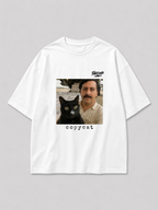 Wit oversized PABLO T-shirt van FAKESNIFF, print 'copycat': een zwarte kat naast een man met snor voor gestapelde koffiezakken