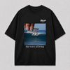 Zwart oversized THE WAVE OF LIVING T-shirt van FAKESNIFF, print 'the wave of living': een hand houdt een scheermesje boven een golf waarop drie surfers rijden