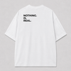 Achterkant van een wit oversized FAKESNIFF T-shirt, met NOTHING. IS. REAL. over de schouders gedrukt
