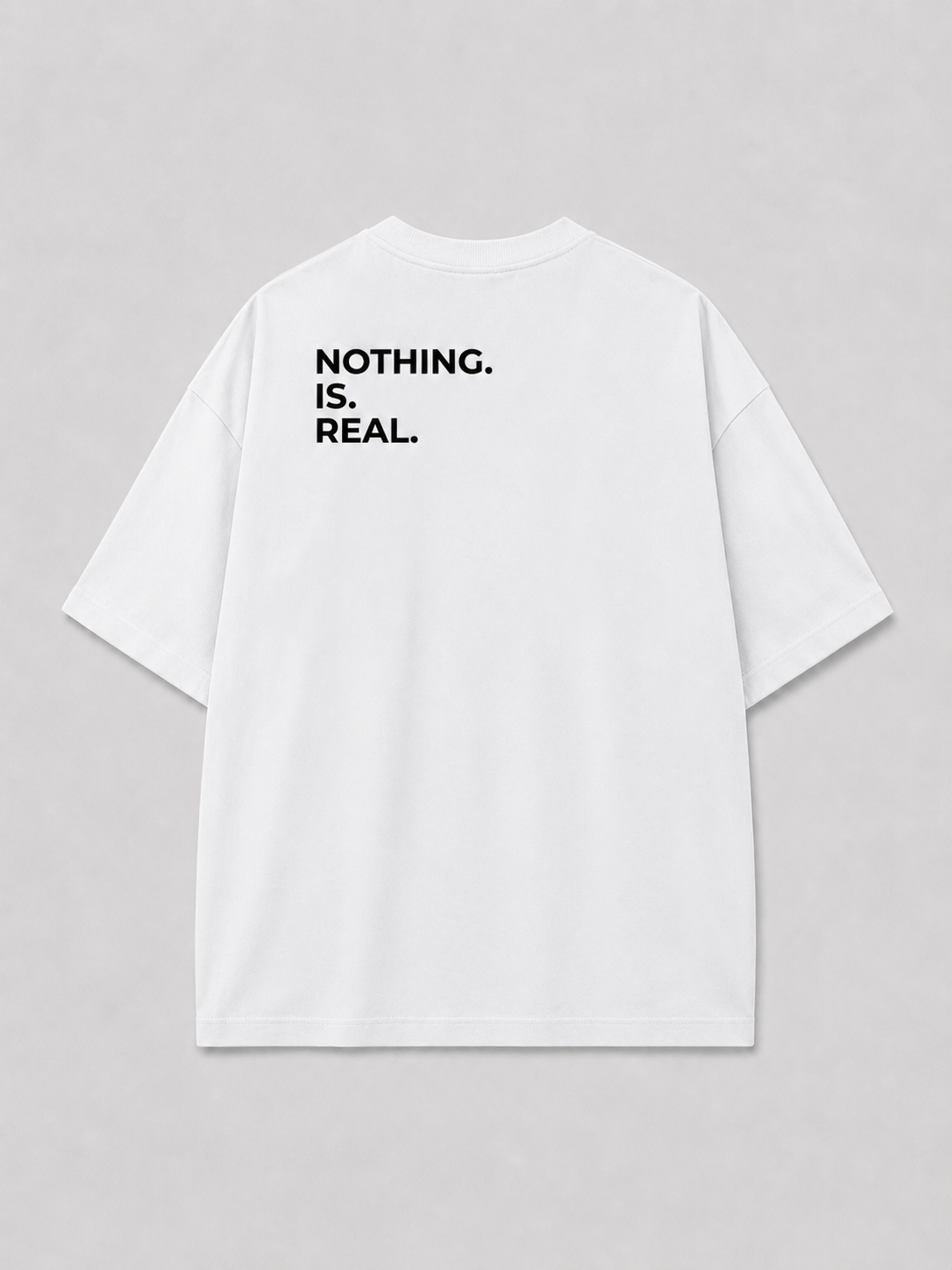 Achterkant van een wit oversized FAKESNIFF T-shirt, met NOTHING. IS. REAL. over de schouders gedrukt