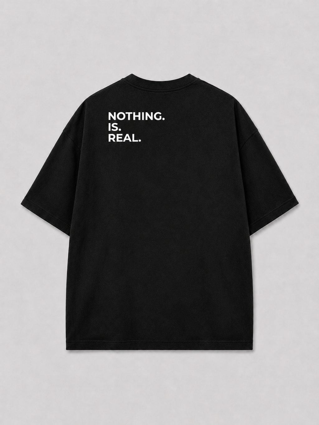 Achterkant van een zwart oversized FAKESNIFF T-shirt, met NOTHING. IS. REAL. over de schouders gedrukt