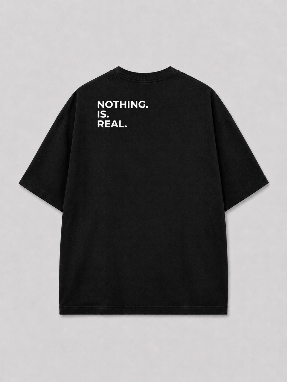 Achterkant van een zwart oversized FAKESNIFF T-shirt, met NOTHING. IS. REAL. over de schouders gedrukt