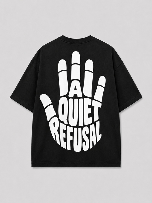 Achterkant van het zwarte A QUIET REFUSAL T-shirt van FAKESNIFF, met een grote witte opgeheven hand waarin de woorden A QUIET REFUSAL de handpalm vormen